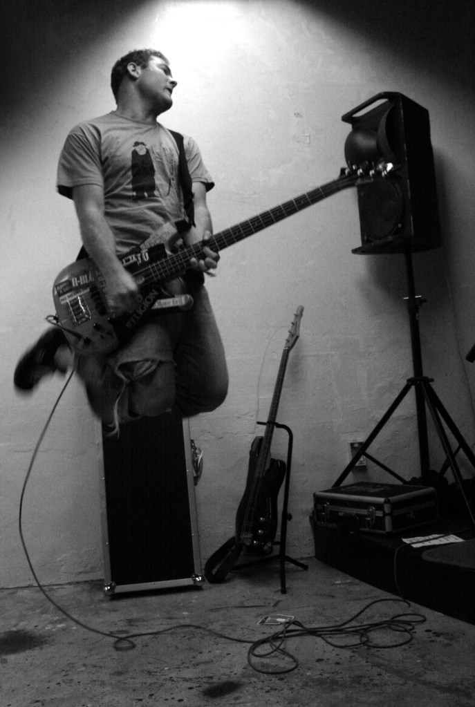 Aaron Lloydd playing bass whilst 2ft in the air.